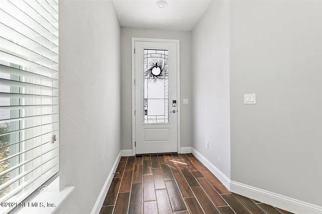 a view of a hallway with wooden floor and closet
