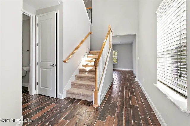 a view of a hallway with wooden floor and staircase