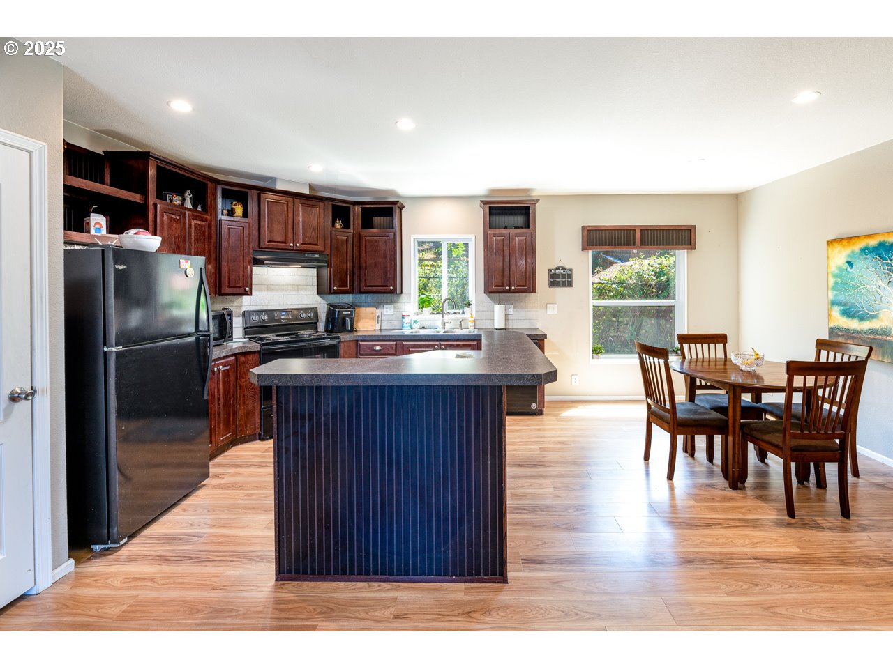 466 South 71st Street Springfield, OR 97478 - Photo 6 of 33 a kitchen with stainless steel appliances wooden floor and dining table