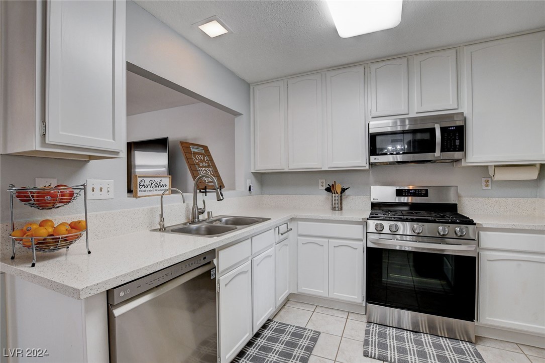 3153 Viewcrest Avenue Henderson, NV 89014 - Photo 11 of 49 Nicely updated kitchen features lots of modern white cabinets, quartz counters, newer Stainless Steel appliances, pantry and easy-care tile flooring.