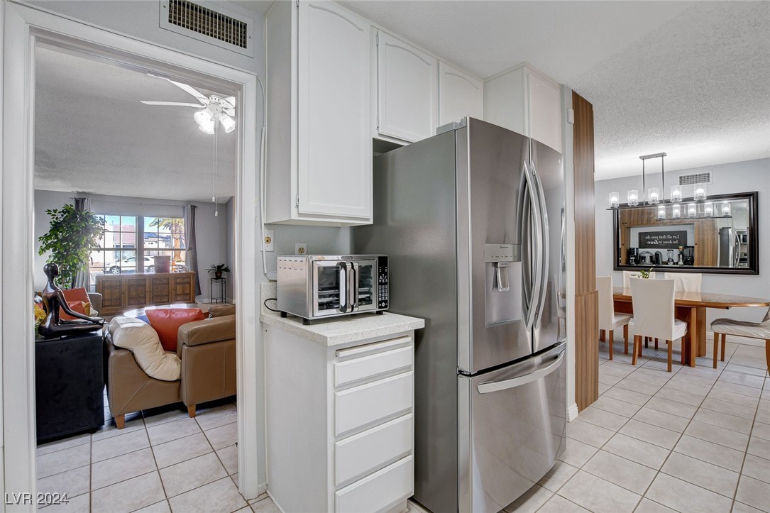 3153 Viewcrest Avenue Henderson, NV 89014 - Photo 13 of 49 Nicely updated kitchen features lots of modern white cabinets, quartz counters, newer Stainless Steel appliances, pantry and easy-care tile flooring.