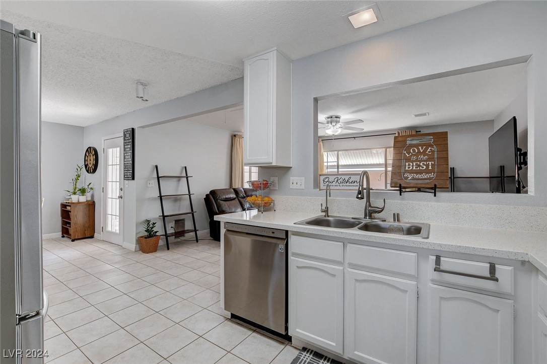 3153 Viewcrest Avenue Henderson, NV 89014 - Photo 14 of 49 Nicely updated kitchen features lots of modern white cabinets, quartz counters, newer Stainless Steel appliances, pantry and easy-care tile flooring.