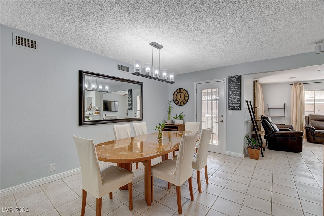 3153 Viewcrest Avenue Henderson, NV 89014 - Photo 15 of 49 Dining area off the Kitchen includes a built-in Hutch and can be used as everyday dining or a Formal Dining Room. Features a door to the backyard patio with built-in BBQ for convenience. NOte the beautiful lighting fixture.