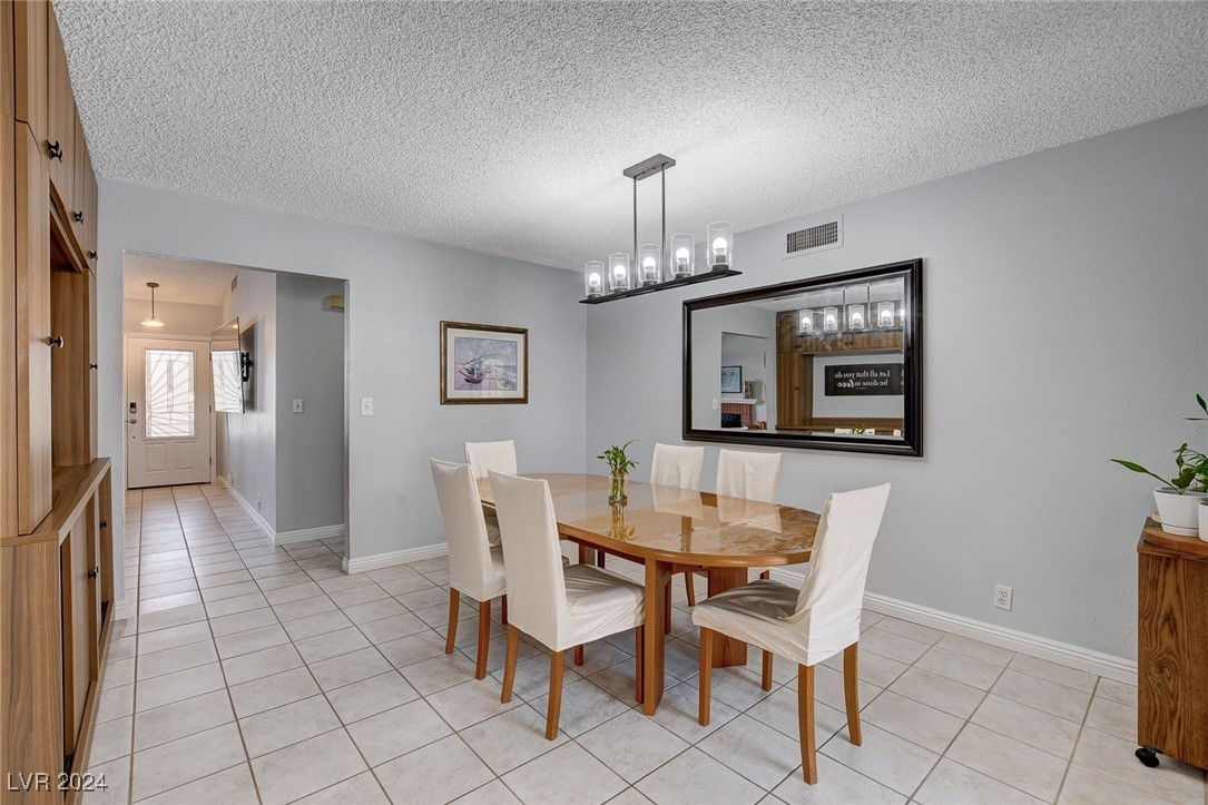 3153 Viewcrest Avenue Henderson, NV 89014 - Photo 16 of 49 Dining area off the Kitchen includes a built-in Hutch and can be used as everyday dining or a Formal Dining Room. Features a door to the backyard patio with built-in BBQ for convenience. NOte the beautiful lighting fixture.