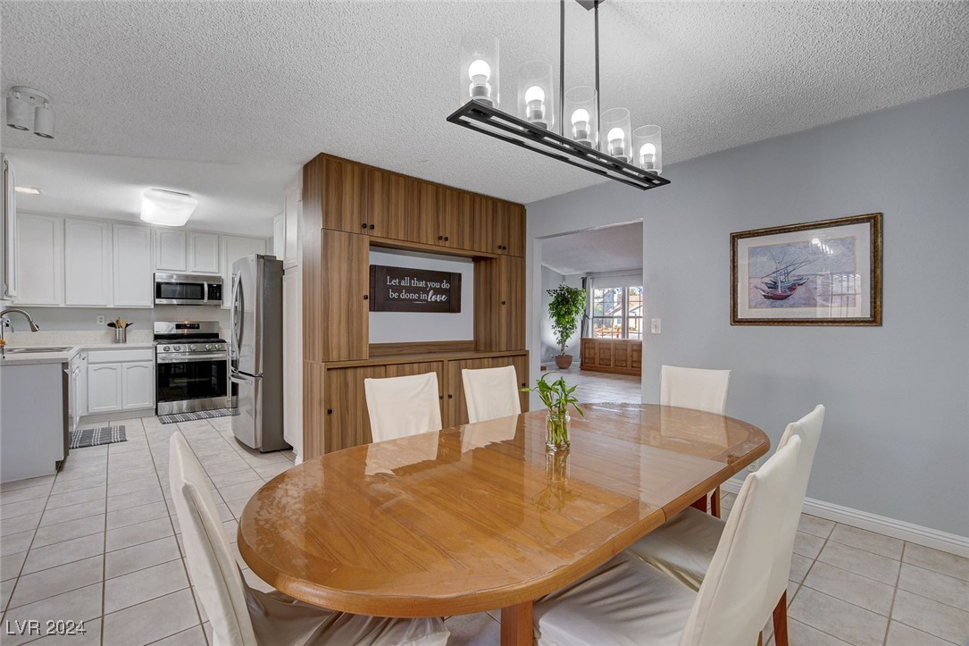 3153 Viewcrest Avenue Henderson, NV 89014 - Photo 17 of 49 Dining area off the Kitchen includes a built-in Hutch and can be used as everyday dining or a Formal Dining Room. Features a door to the backyard patio with built-in BBQ for convenience. NOte the beautiful lighting fixture.