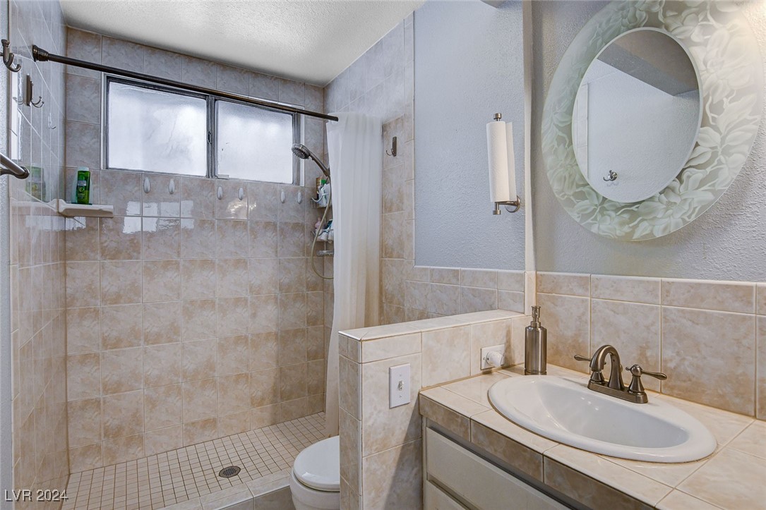 3153 Viewcrest Avenue Henderson, NV 89014 - Photo 28 of 49 Master Bath includes a second mirrored closet, dual sink tiled vanity and coordinating tiled walk-in shower. Note the beautiful etched wall mirrors!