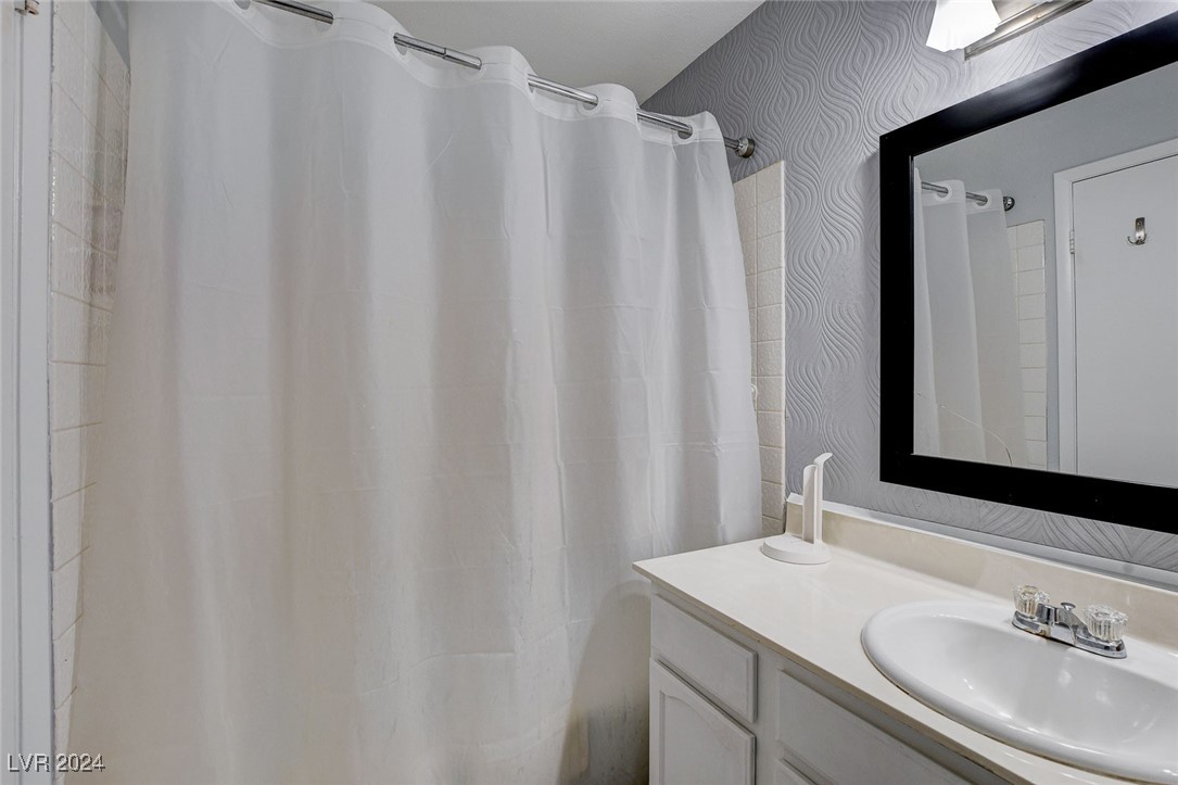 3153 Viewcrest Avenue Henderson, NV 89014 - Photo 32 of 49 Hall Bath features modern white cabinet with cultured marble vanity top and tub/shower combo.