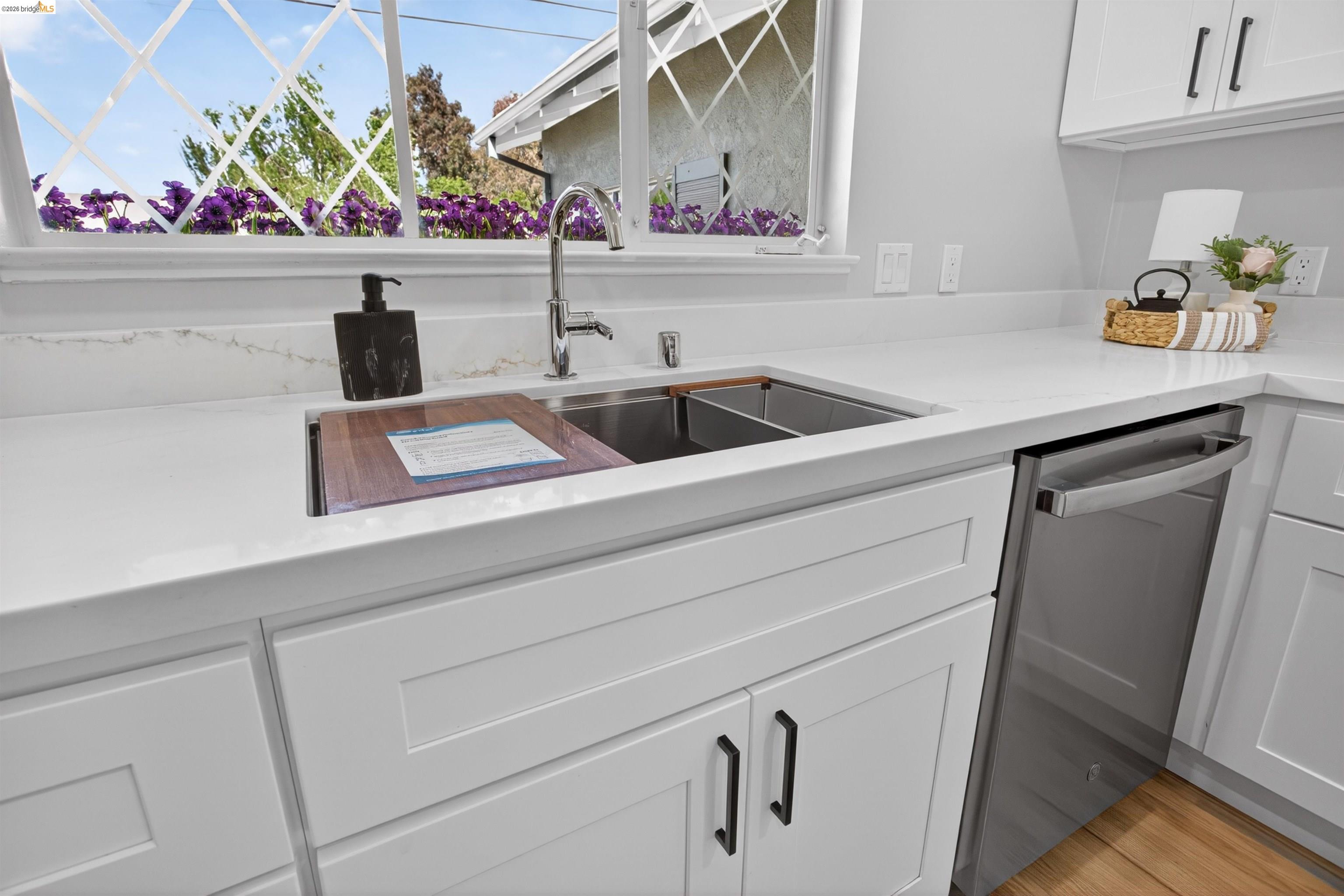 4321 Davis Way Livermore, CA 94550 - Photo 13 of 34 Kitchen featuring white shaker cabinetry, light-toned countertops, a stainless steel double basin sink with a chrome faucet, and a stainless steel dishwasher