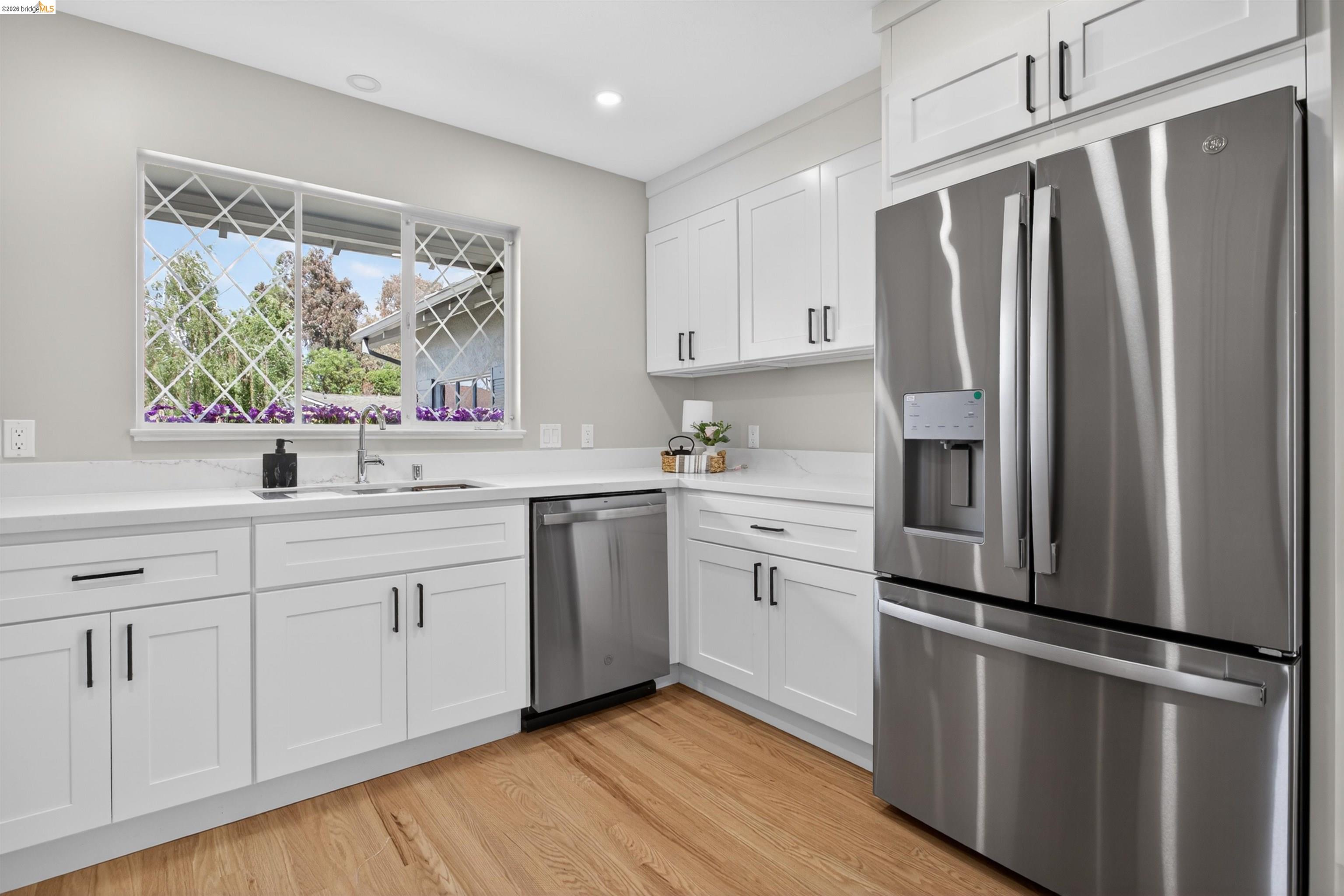4321 Davis Way Livermore, CA 94550 - Photo 14 of 34 Modern kitchen featuring white shaker cabinetry with black hardware, stainless steel appliances, and light-toned countertops