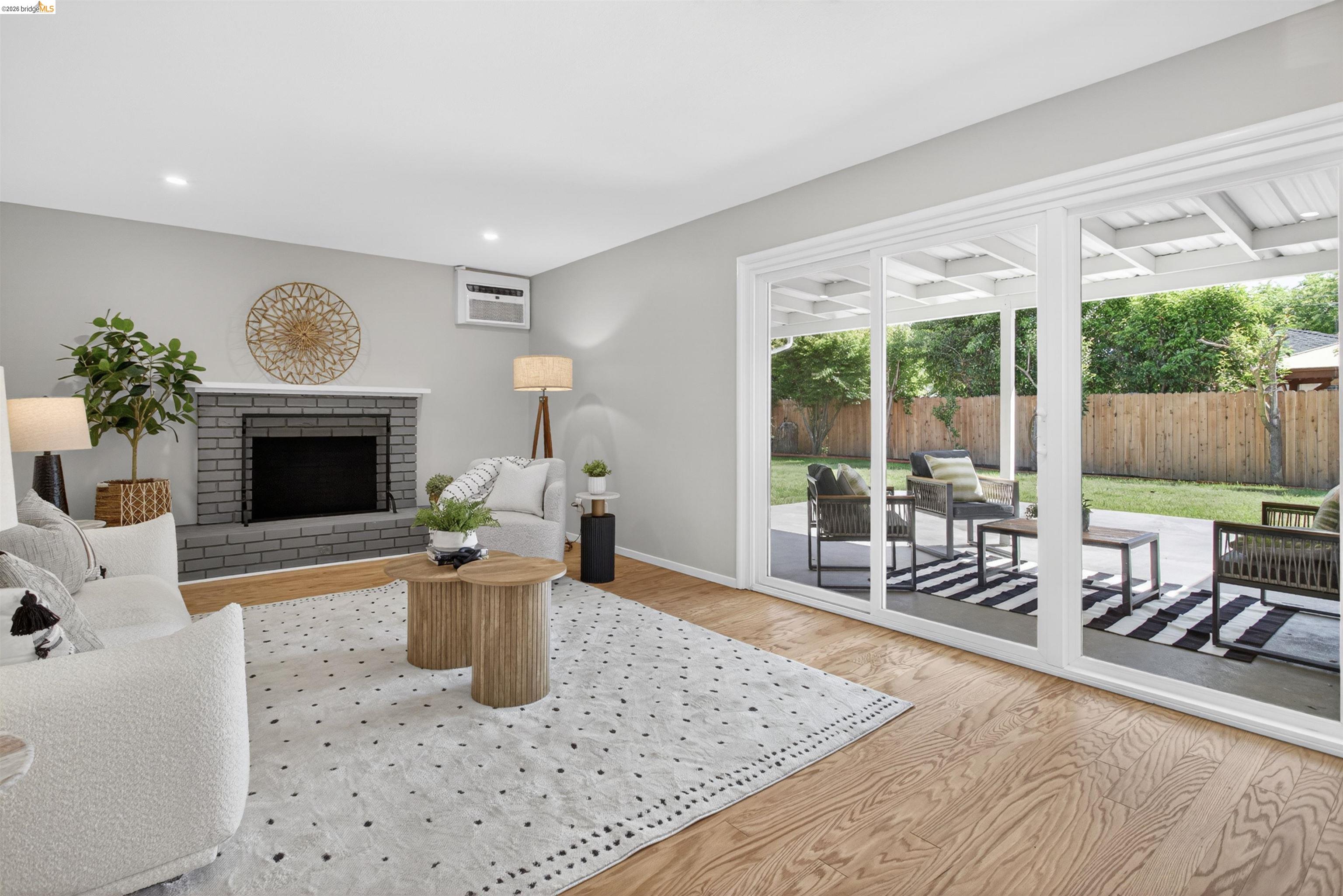 4321 Davis Way Livermore, CA 94550 - Photo 16 of 34 Living area featuring wood-finish flooring and a gray brick fireplace with a white mantel
