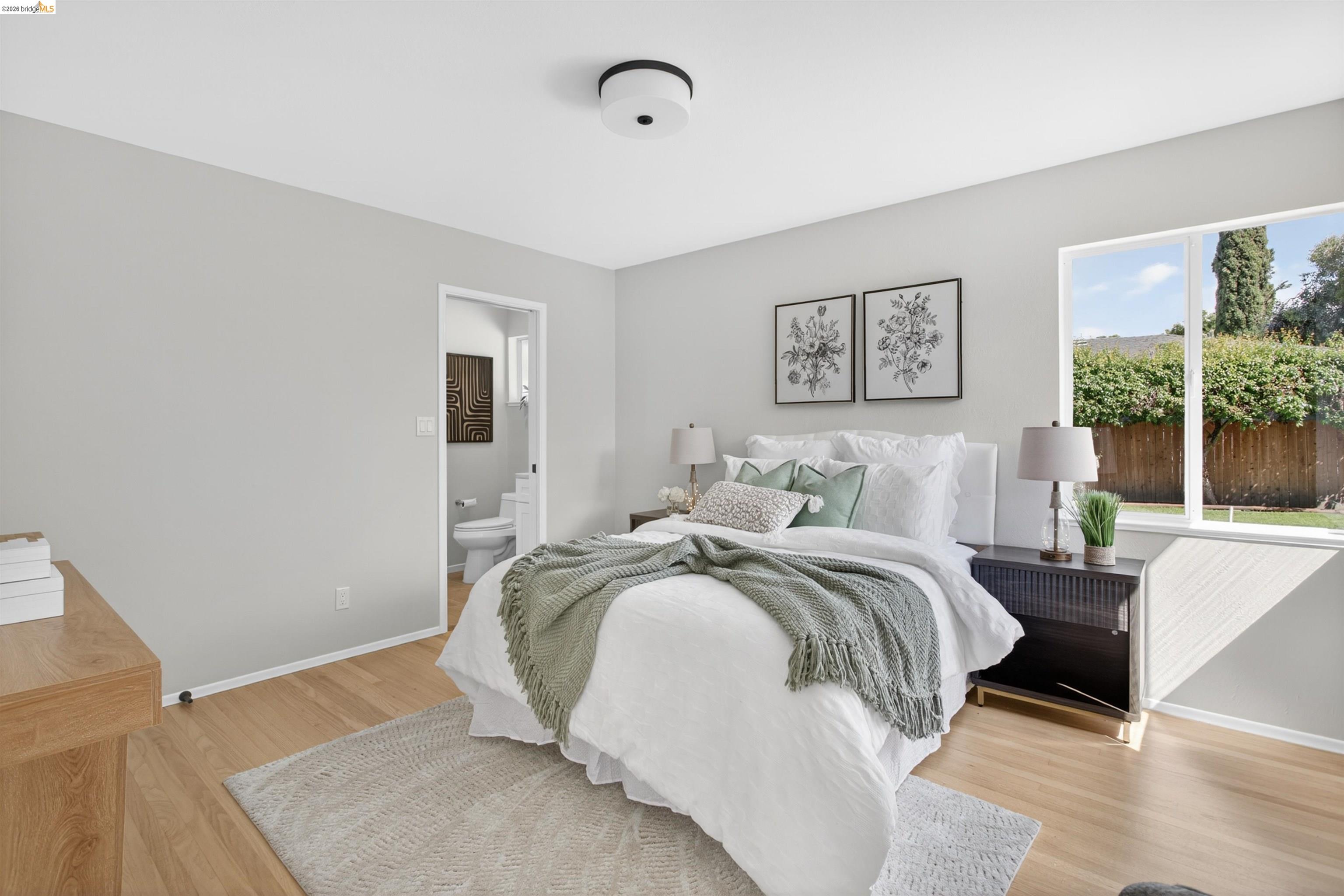 4321 Davis Way Livermore, CA 94550 - Photo 23 of 34 Light-filled room featuring wood-finish flooring, a large window, a ceiling-mounted light fixture, and an open doorway