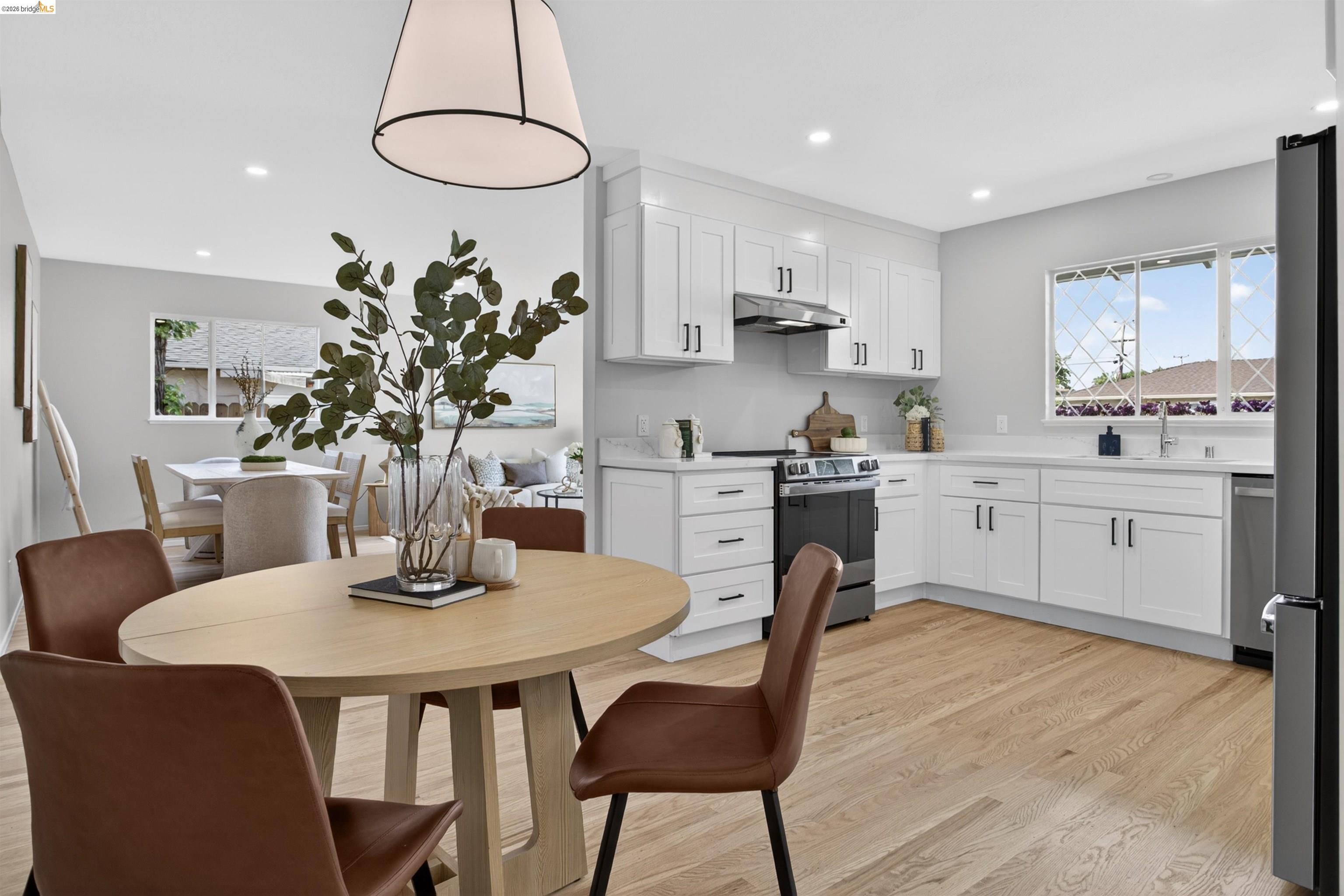 4321 Davis Way Livermore, CA 94550 - Photo 10 of 34 Open-concept kitchen featuring white shaker cabinetry, light-tone wood-finish flooring, recessed lighting, and a window above the sink