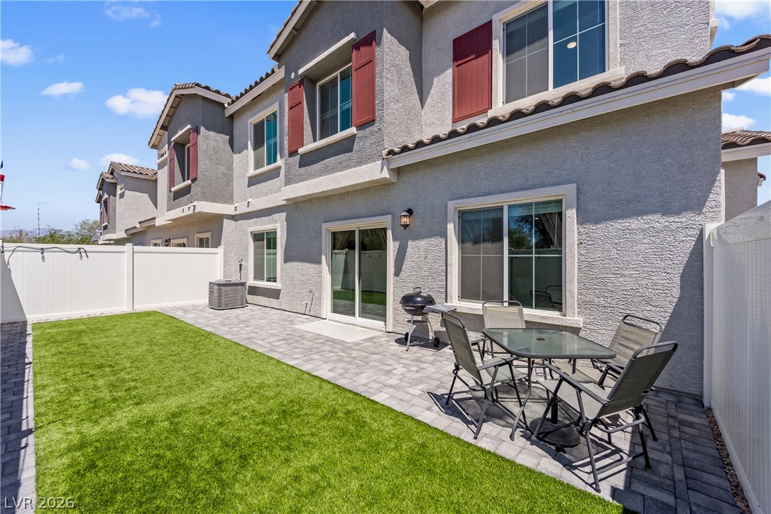 7204 North Decatur Boulevard, Unit 5 North Las Vegas, NV 89084 - Photo 22 of 34 An inviting paved patio borders a level lawn beneath stucco exterior walls.