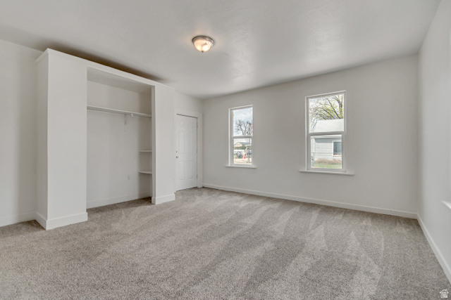 8831 South 400 East Sandy, UT 84070 - Photo 16 of 26 Unfurnished bedroom with light colored carpet and two closets