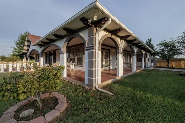 a view of a house with a small yard plants and large tree