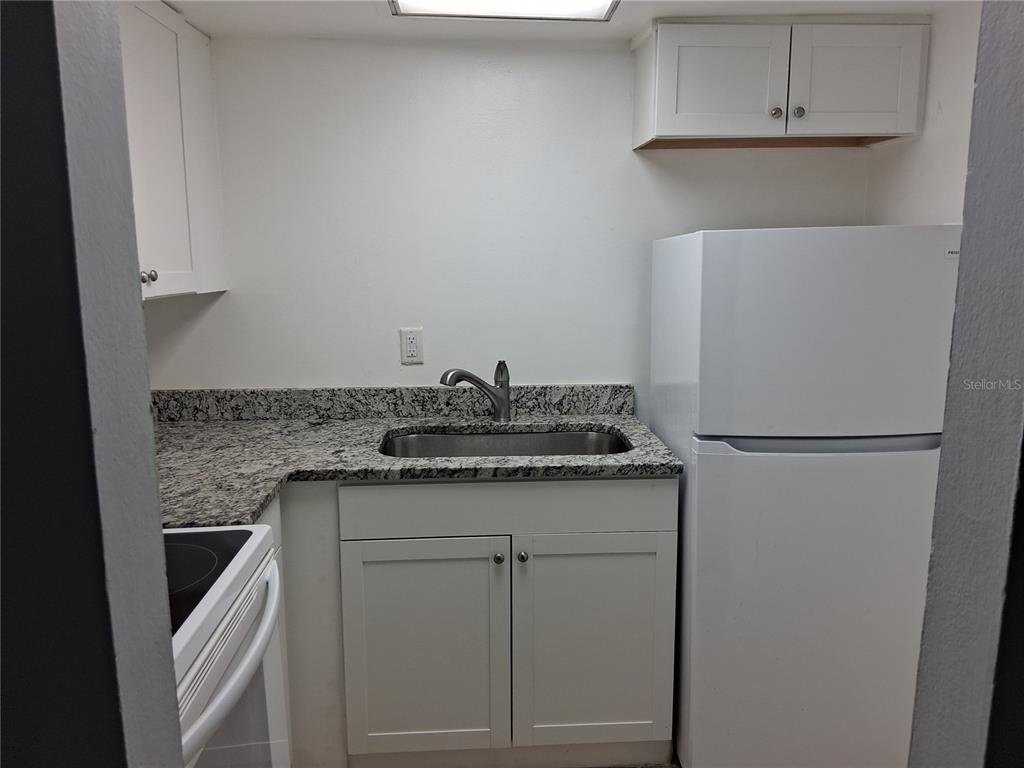 958 Lake Destiny Road, Unit D Altamonte Springs, FL 32714 - Photo 7 of 16 a kitchen with a sink and a refrigerator