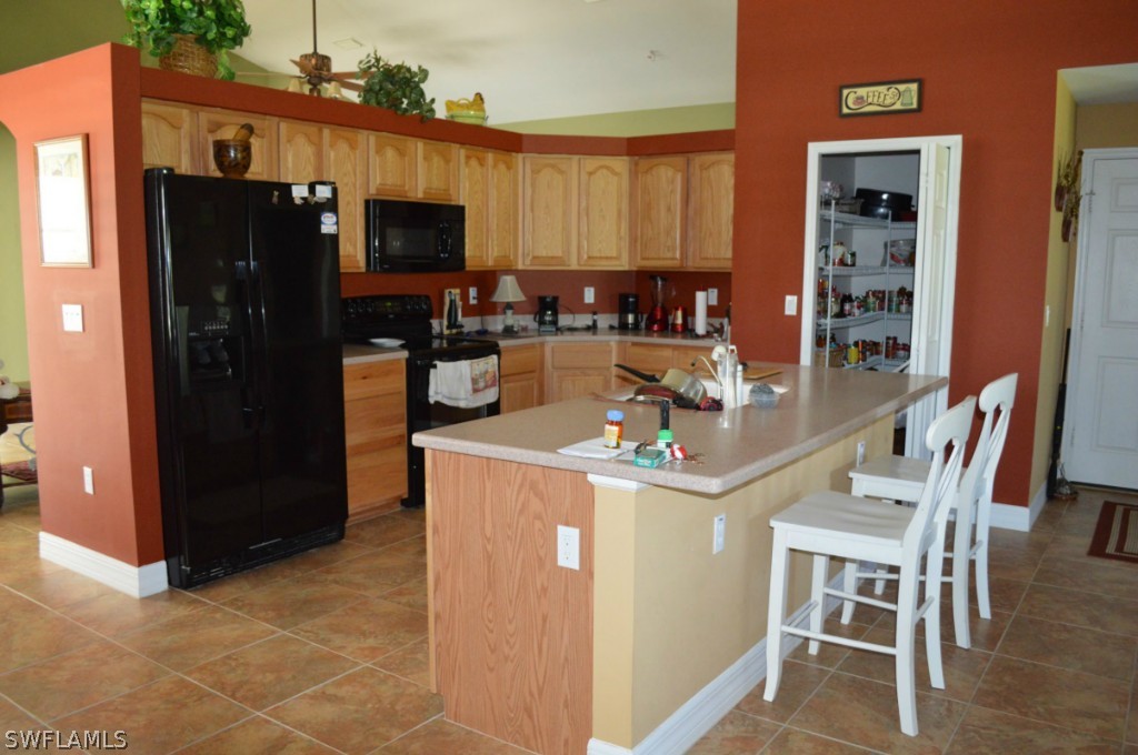 21951 Claytor Road Alva, FL 33920 - Photo 6 of 17 a kitchen with stainless steel appliances granite countertop a refrigerator and a stove top oven