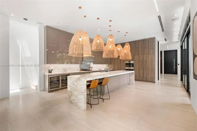 a large kitchen with kitchen island a large counter space a sink stainless steel appliances and cabinets