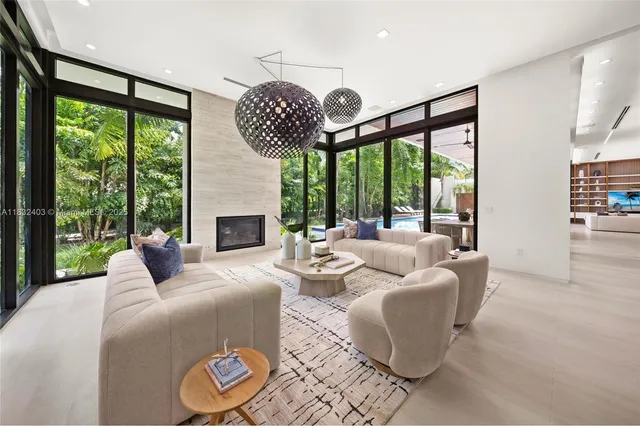 a living room with patio fireplace furniture and a large window