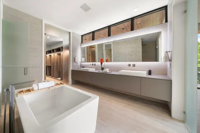 a living room with stainless steel appliances kitchen island granite countertop a sink and a refrigerator