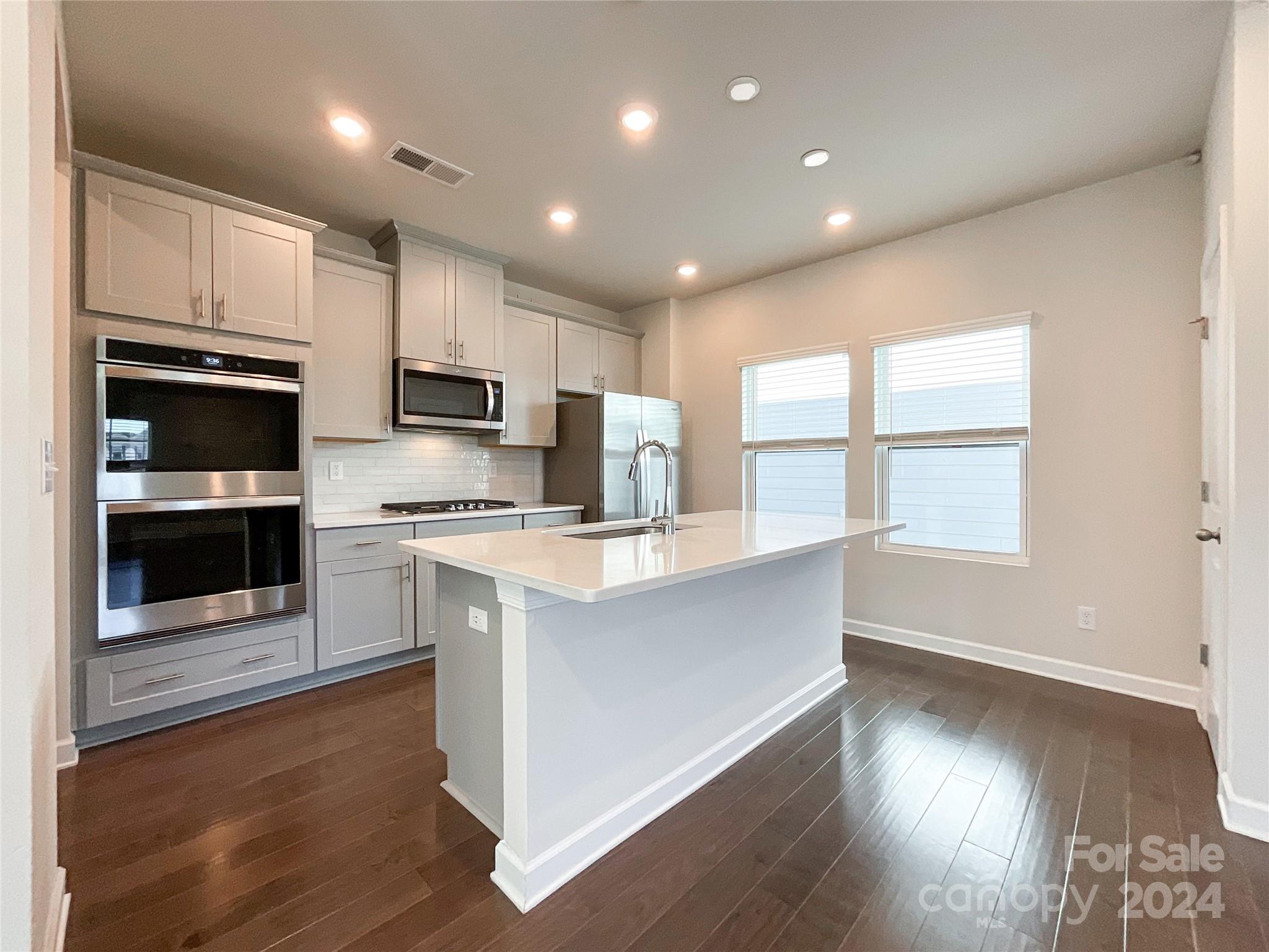 137 Cedar Knoll Circle Pineville, NC 28134 - Photo 11 of 48 a kitchen with stainless steel appliances granite countertop a stove a sink and a microwave