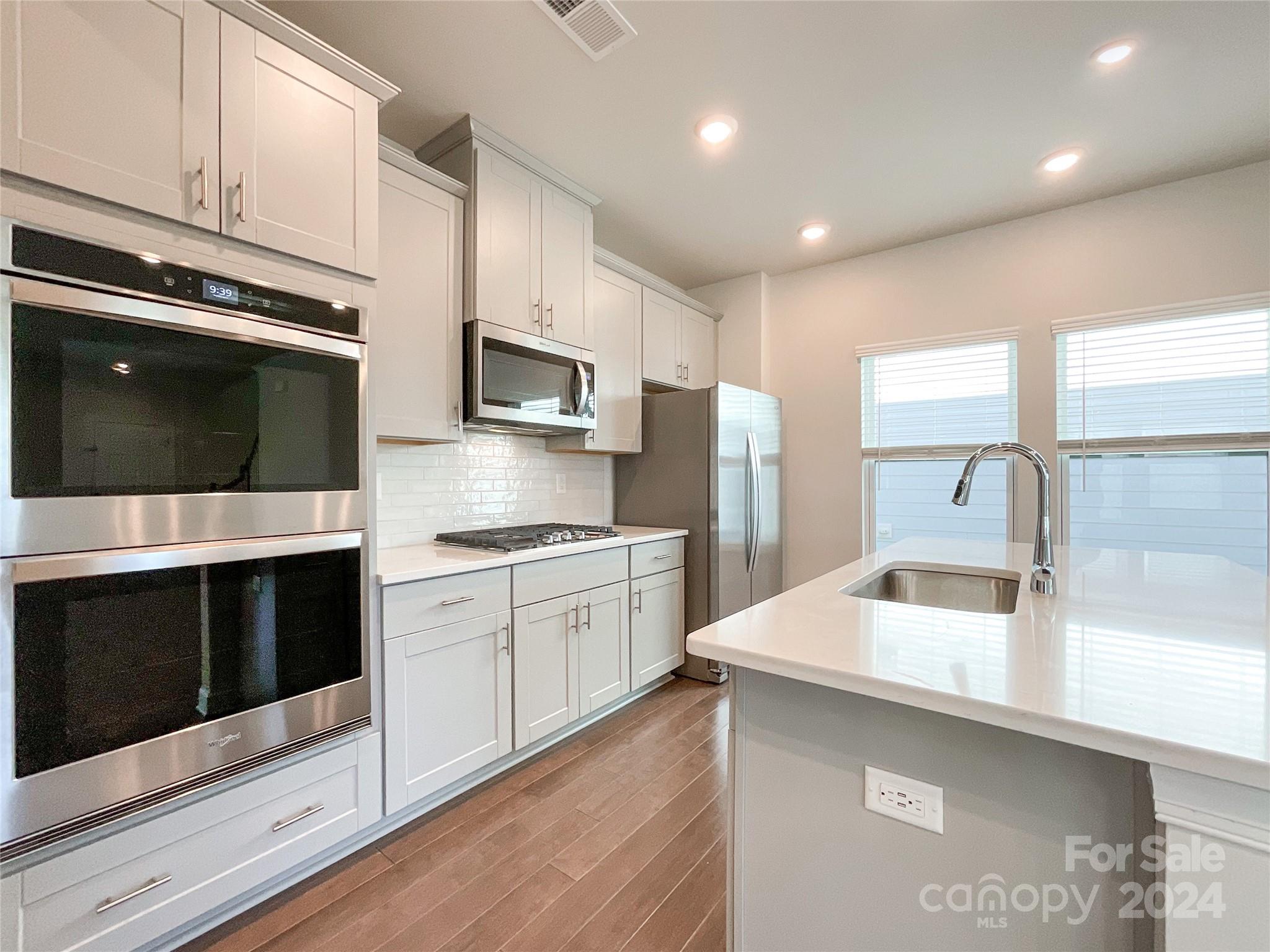 137 Cedar Knoll Circle Pineville, NC 28134 - Photo 16 of 48 a kitchen with stainless steel appliances kitchen island granite countertop a sink and a microwave