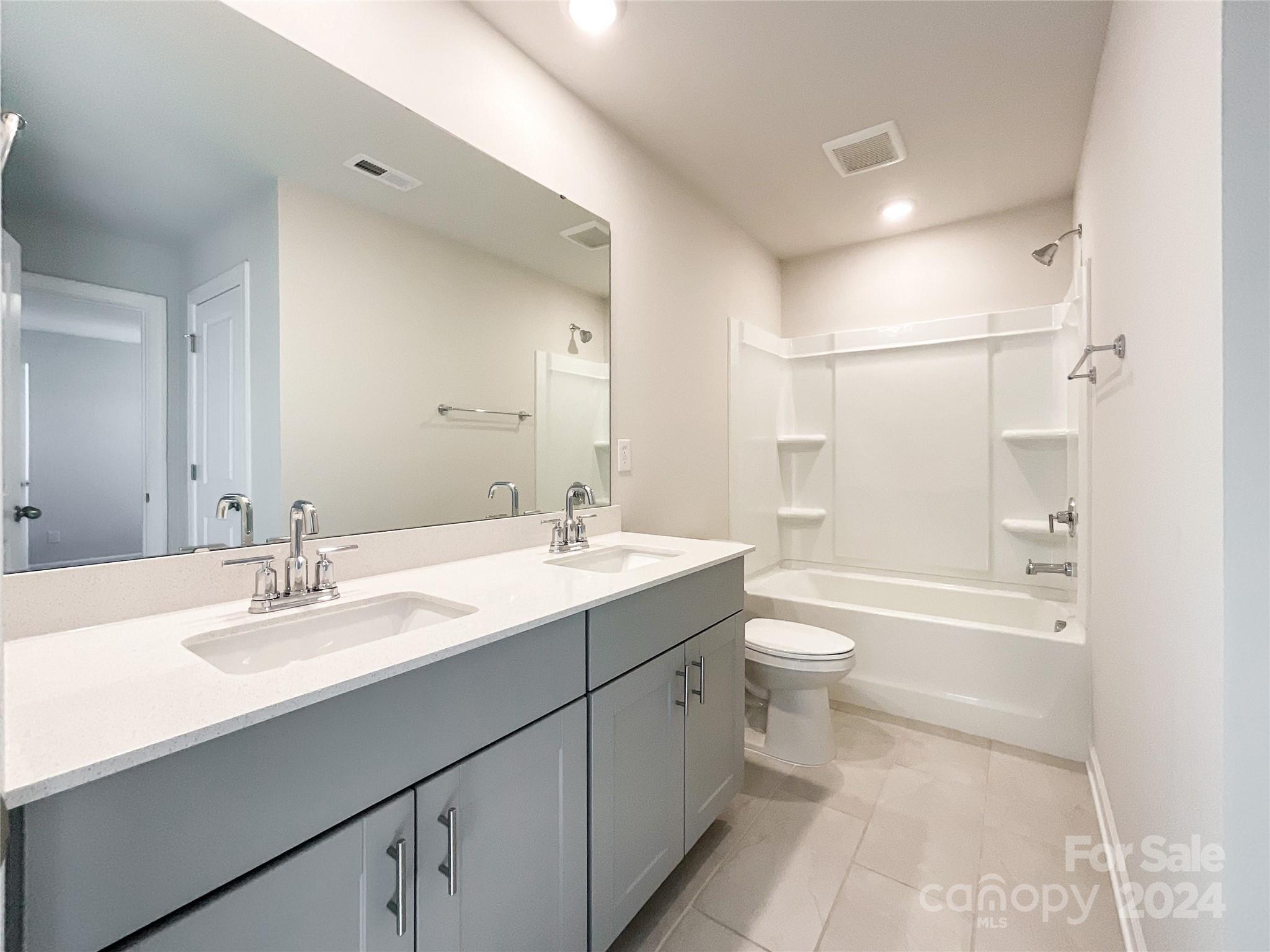 137 Cedar Knoll Circle Pineville, NC 28134 - Photo 40 of 48 a bathroom with a double vanity sink toilet mirror and shower