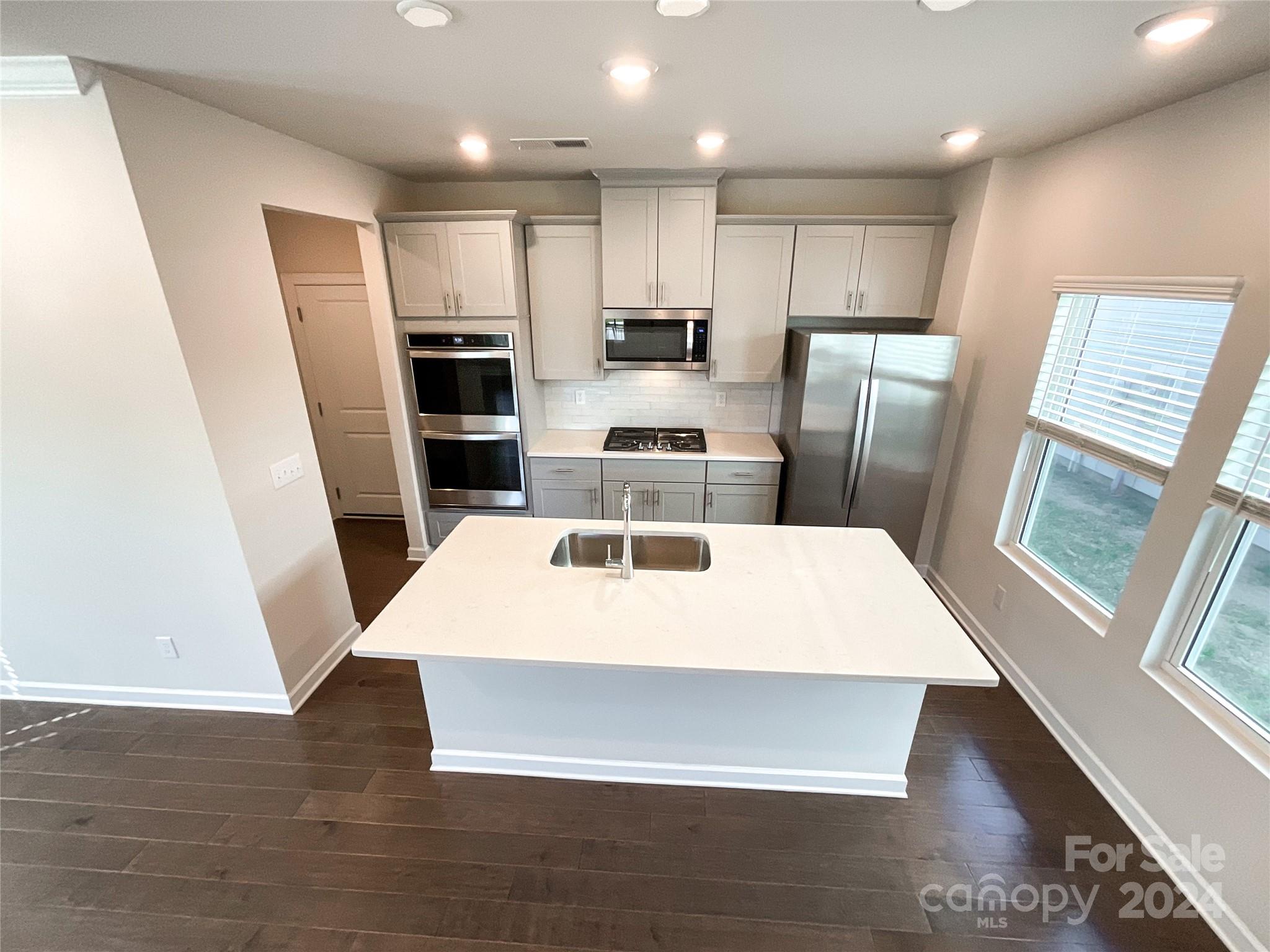 137 Cedar Knoll Circle Pineville, NC 28134 - Photo 4 of 48 a large kitchen with kitchen island a refrigerator a sink a stove a microwave and island