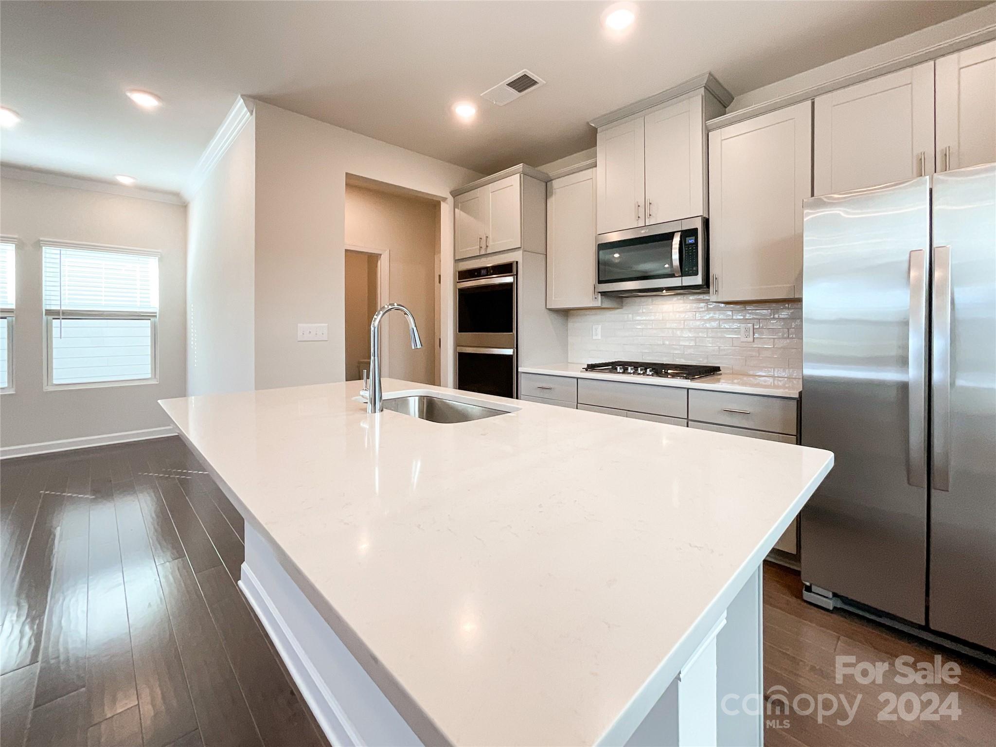 137 Cedar Knoll Circle Pineville, NC 28134 - Photo 5 of 48 a large white kitchen with wooden floor