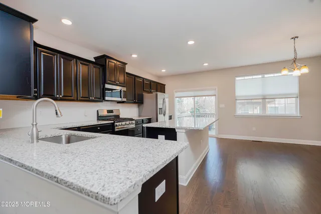 a kitchen with stainless steel appliances granite countertop a sink refrigerator stove and microwave