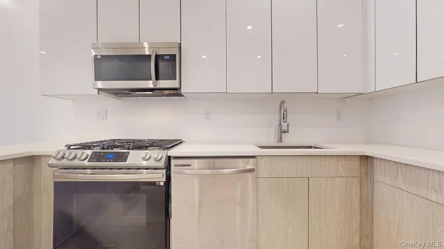 a kitchen with stainless steel appliances granite countertop a sink a stove and microwave