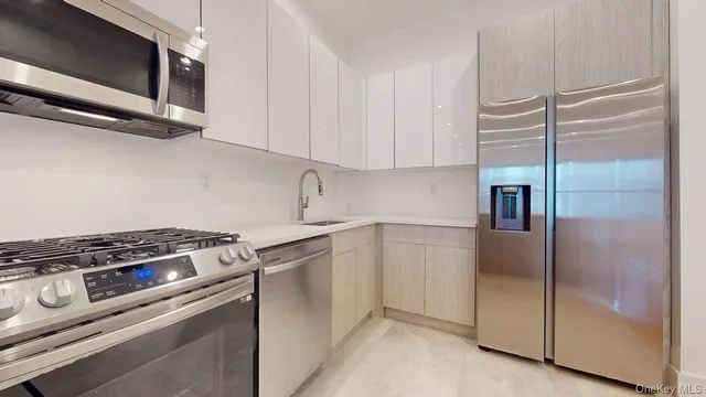 a kitchen with appliances a sink and cabinets