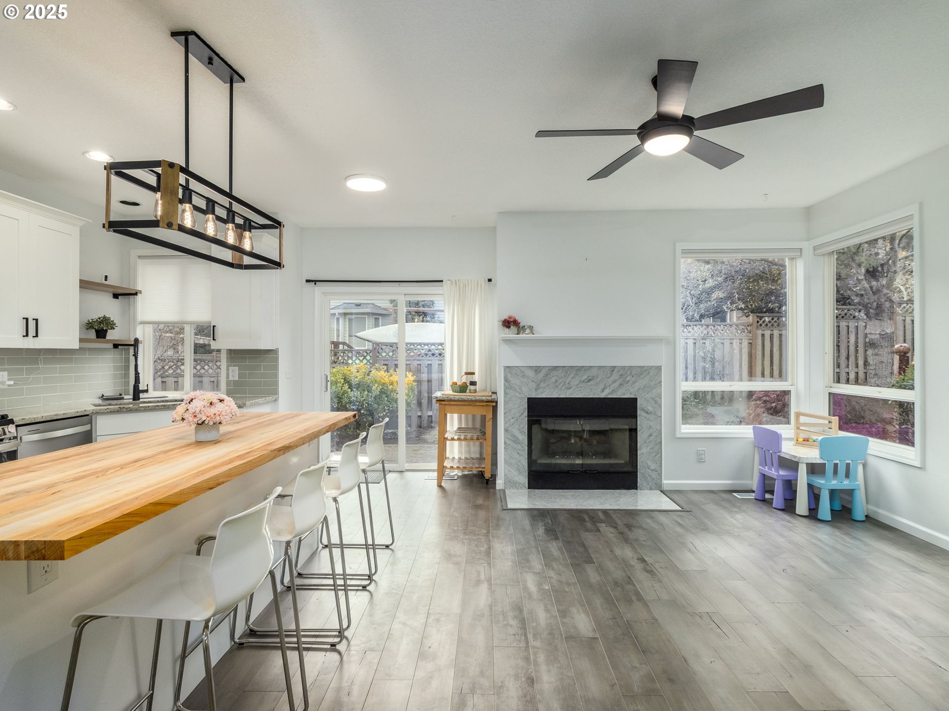 14140 Southwest Chehalem Court Tigard, OR 97223 - Photo 7 of 30 a living room with furniture a fireplace and kitchen view