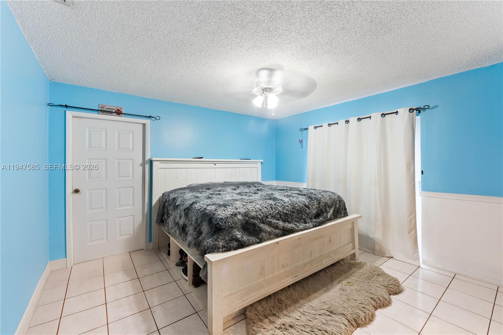 10100 Southwest 50th Court Cooper City, FL 33328 - Photo 11 of 24 a bedroom with a bed and a chandelier