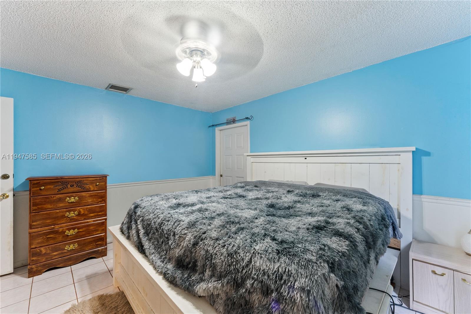 10100 Southwest 50th Court Cooper City, FL 33328 - Photo 12 of 24 a bedroom with a bed and a chandelier