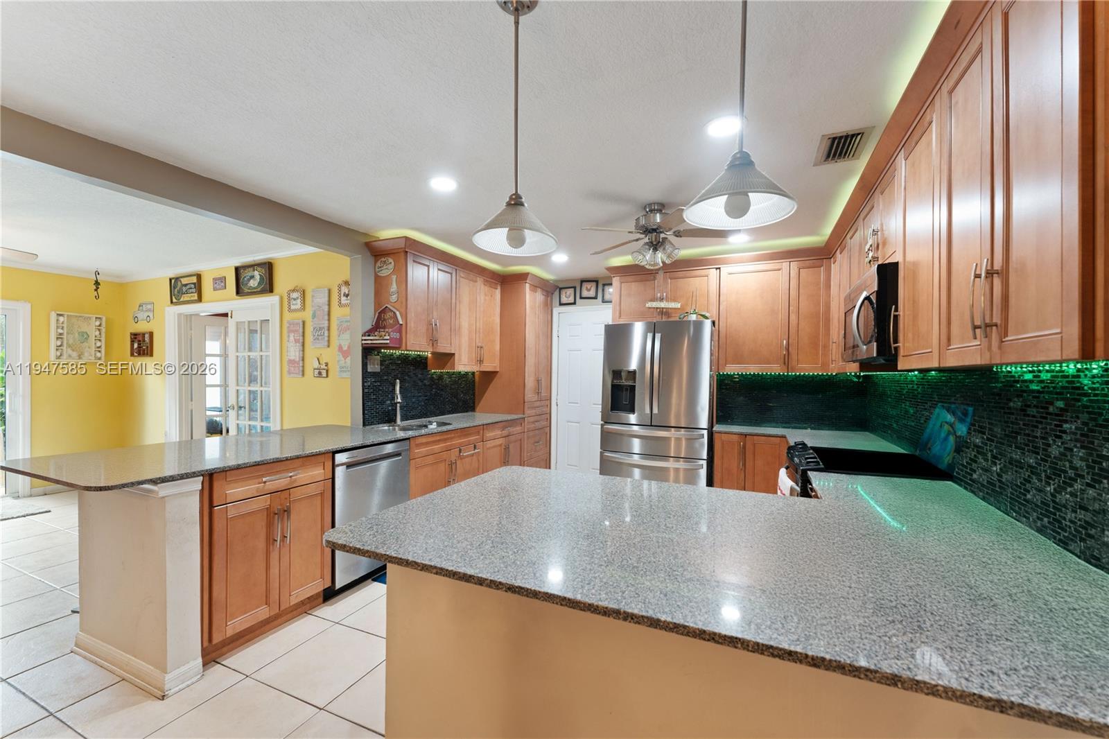 10100 Southwest 50th Court Cooper City, FL 33328 - Photo 5 of 24 a kitchen with stainless steel appliances granite countertop a sink a stove top oven a counter space and cabinets