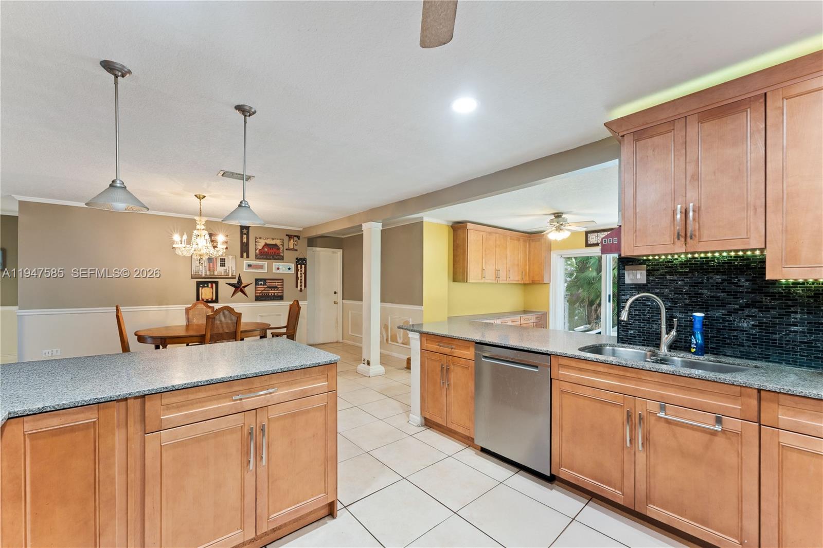 10100 Southwest 50th Court Cooper City, FL 33328 - Photo 8 of 24 a kitchen with stainless steel appliances granite countertop a sink a stove and a wooden floors