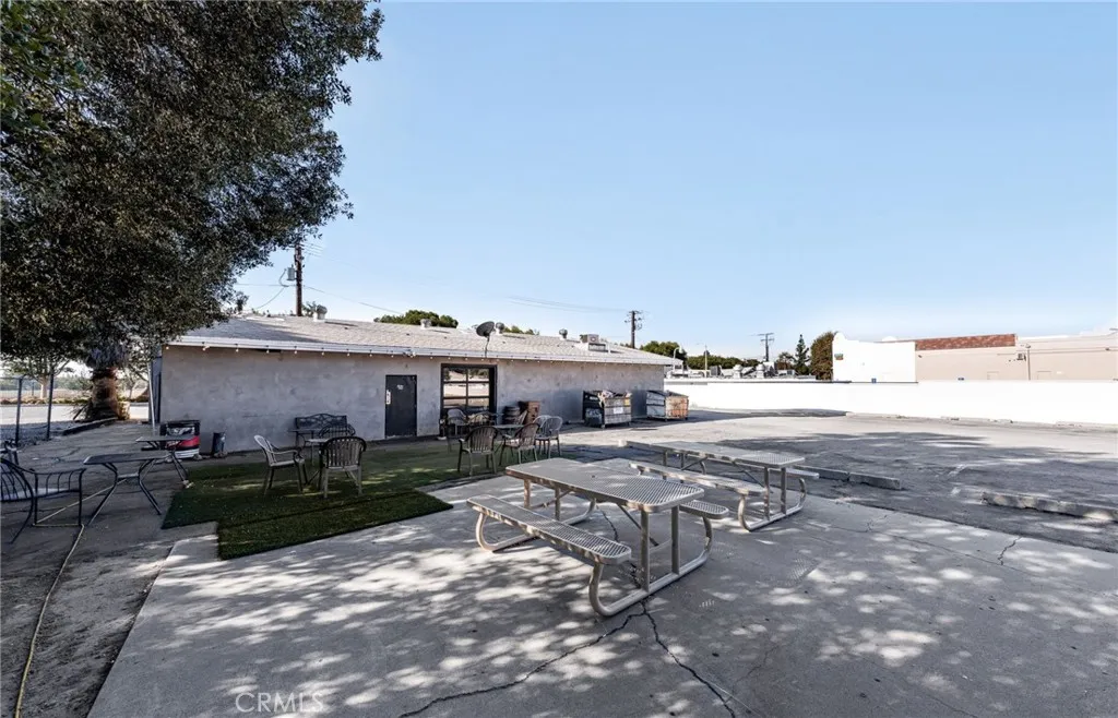 10026 Foothill Boulevard Rancho Cucamonga, CA 91730 - Photo 26 of 34 a view of a backyard with table and chairs a fire pit and large trees