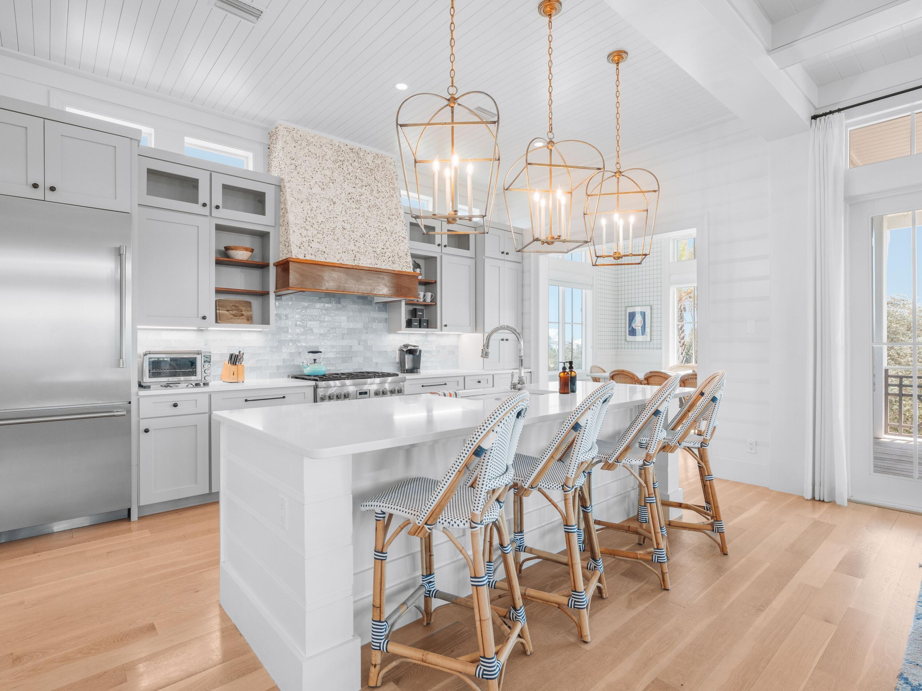 178 Pompano Street Inlet Beach, FL 32461 - Photo 16 of 49 a kitchen with stainless steel appliances granite countertop a dining table chairs and white cabinets