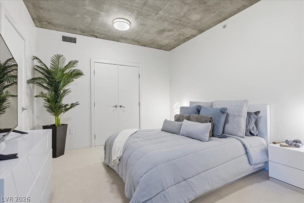 360 East Desert Inn Road, Unit 604 Las Vegas, NV 89109 - Photo 16 of 28 Minimalist design defines this sleeping space, boasting a sleek concrete ceiling and plush carpeting.