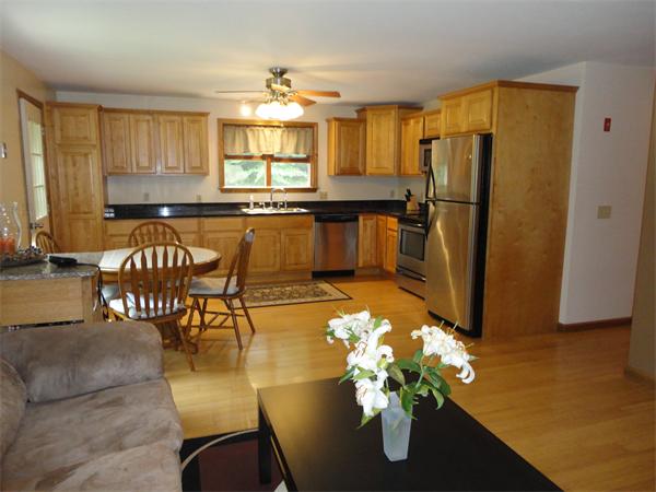 253 NW Road Westhampton, MA 01027 - Photo 9 of 16 a kitchen with stainless steel appliances granite countertop a refrigerator a stove a sink dishwasher with a dining table and chairs