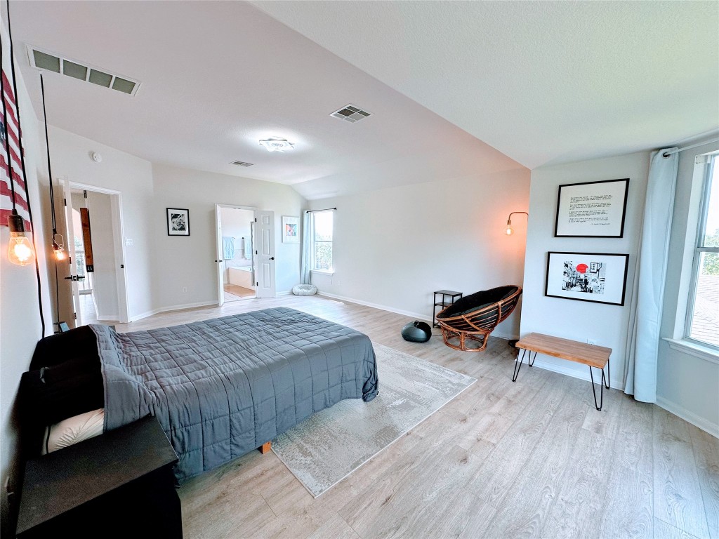12504 Gun Metal Drive Austin, TX 78739 - Photo 20 of 40 a spacious bedroom with a bed and wooden floor