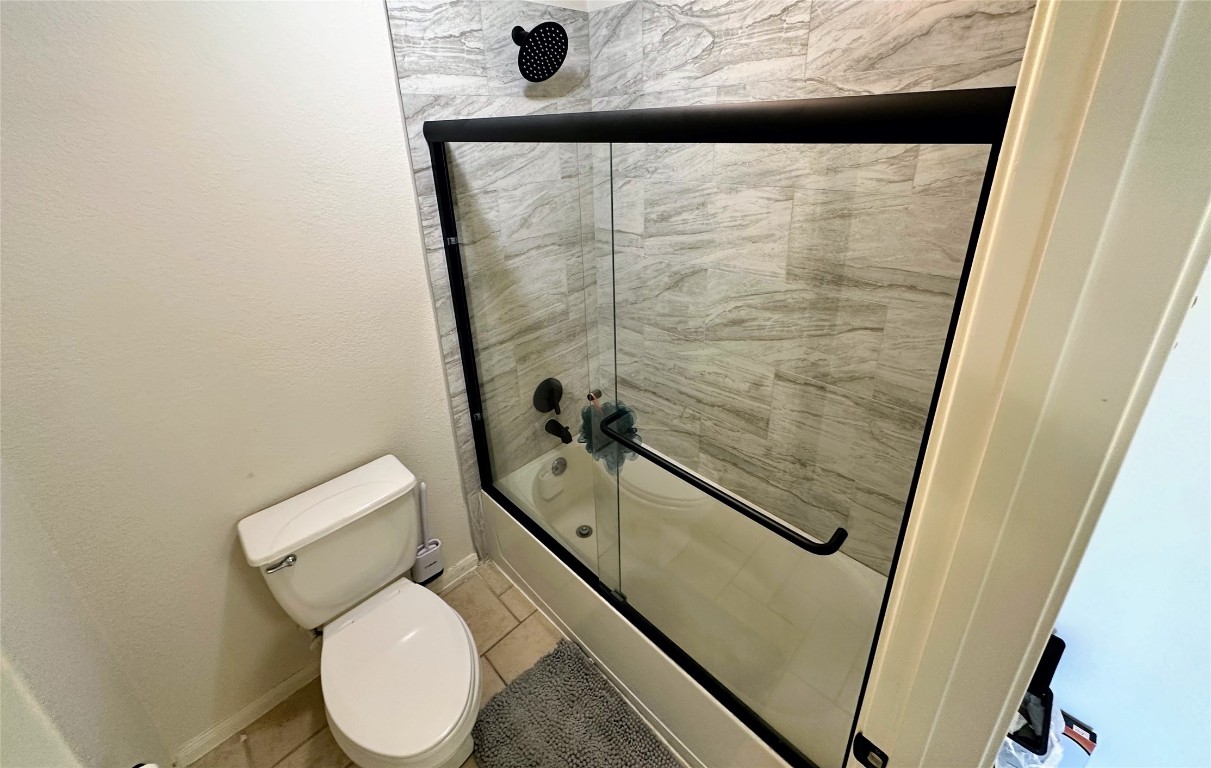 12504 Gun Metal Drive Austin, TX 78739 - Photo 32 of 40 a bathroom with a granite countertop toilet and a shower
