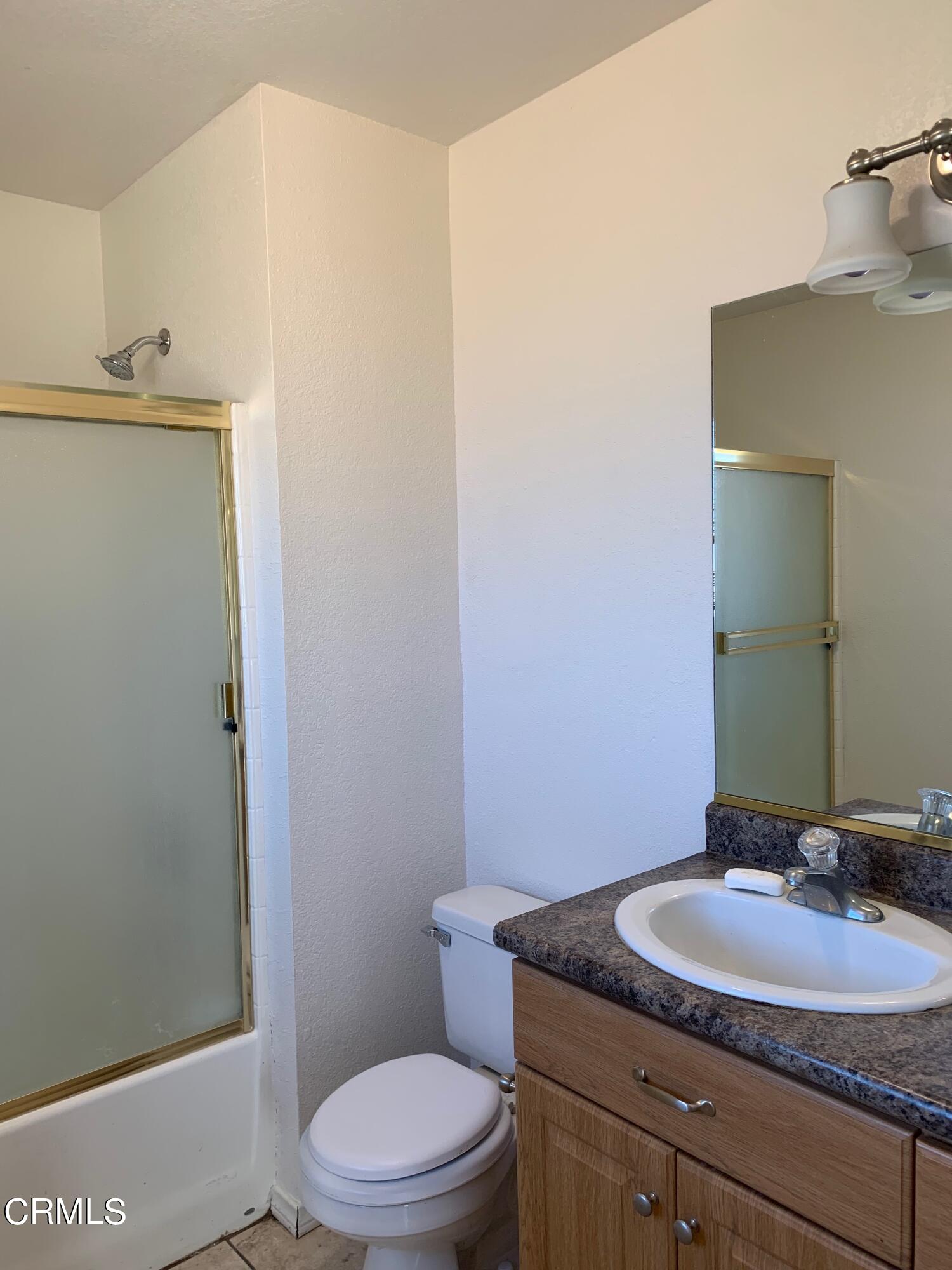 22159 Tehama Road Apple Valley, CA 92308 - Photo 16 of 26 a bathroom with a granite countertop sink toilet and mirror