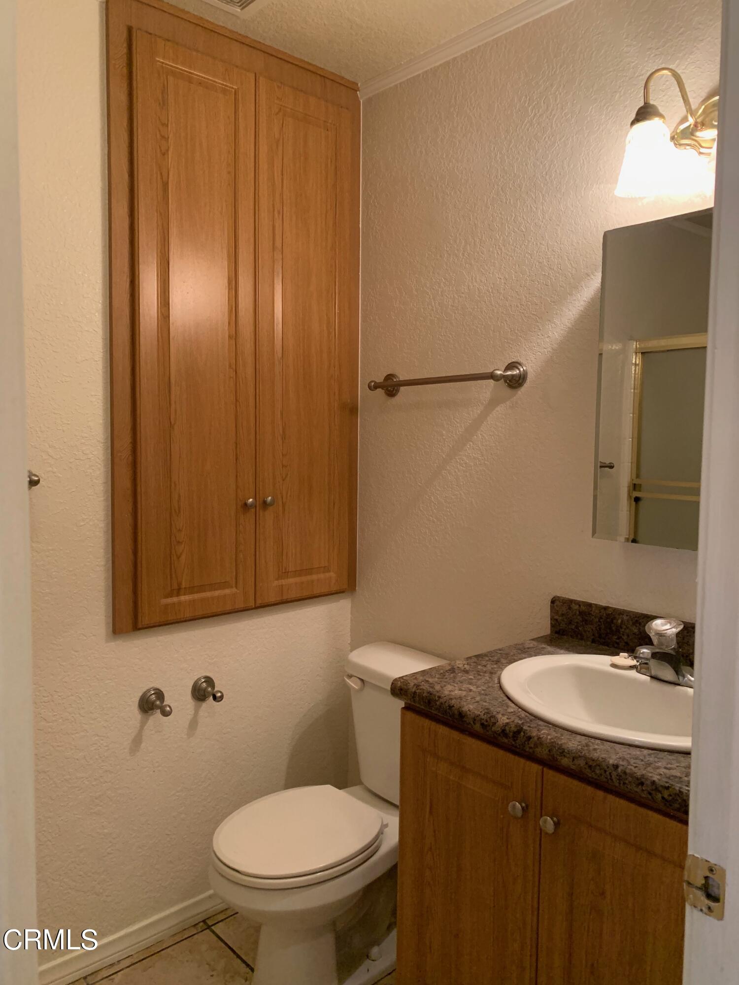 22159 Tehama Road Apple Valley, CA 92308 - Photo 18 of 26 a bathroom with a granite countertop sink toilet and mirror