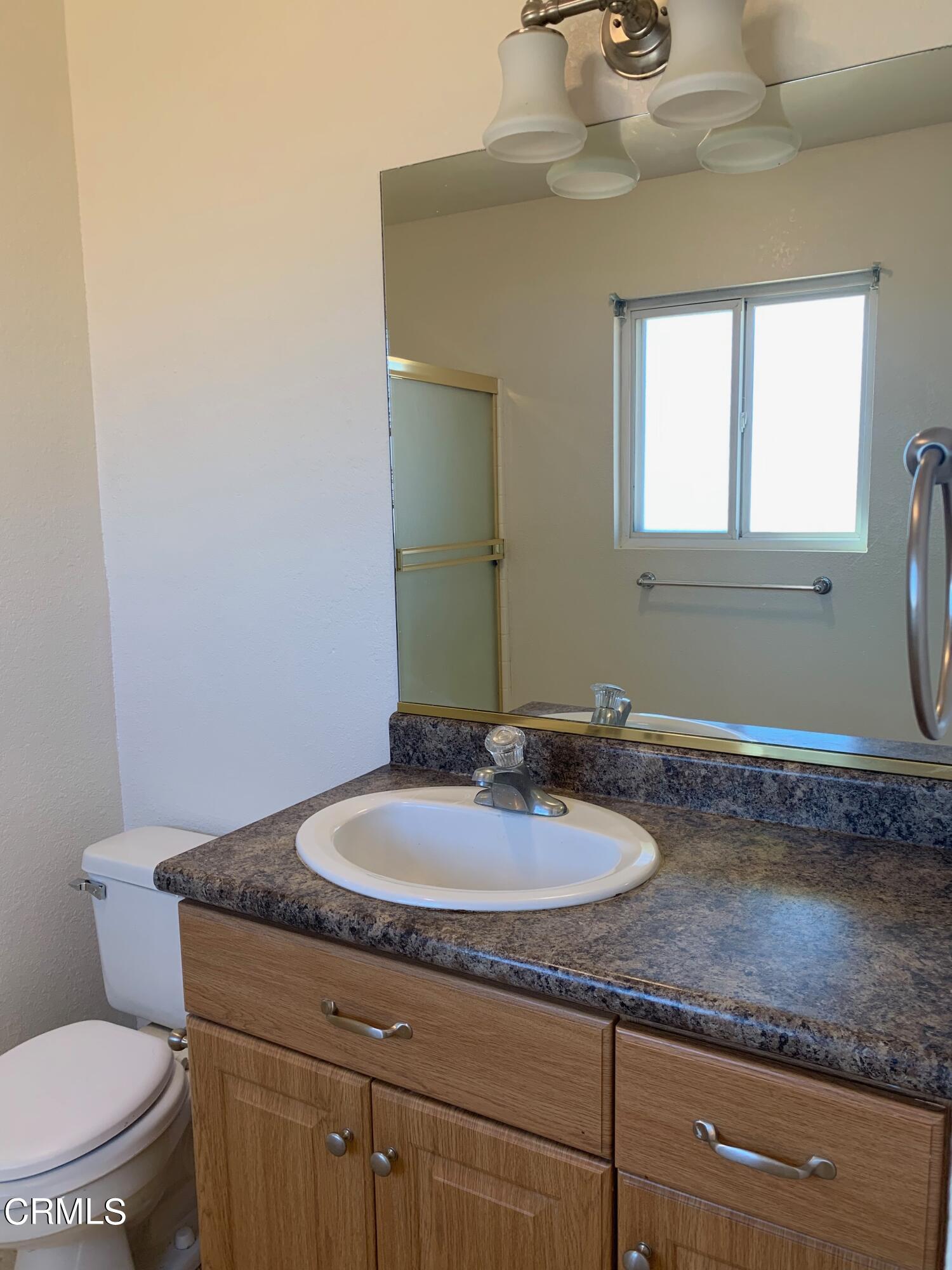 22159 Tehama Road Apple Valley, CA 92308 - Photo 25 of 26 a bathroom with a granite countertop sink a toilet and mirror