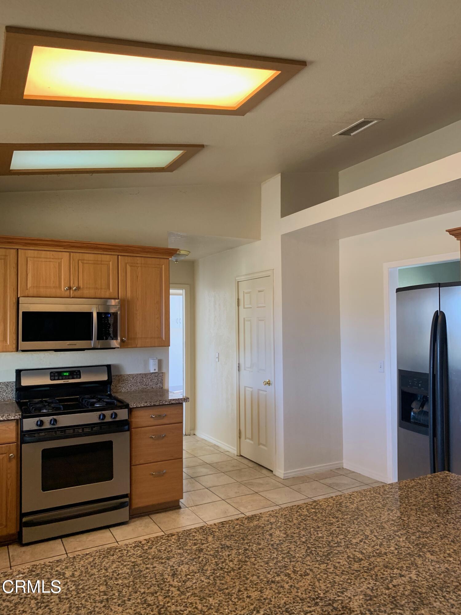 22159 Tehama Road Apple Valley, CA 92308 - Photo 6 of 26 a kitchen with stainless steel appliances a stove a microwave and a refrigerator