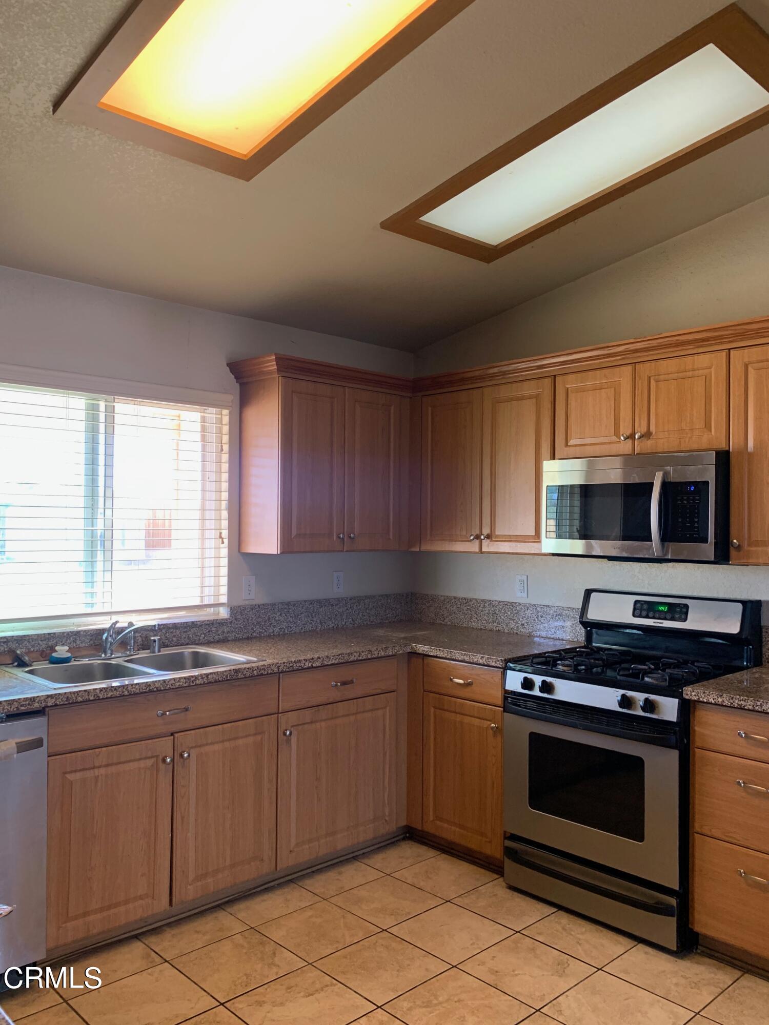 22159 Tehama Road Apple Valley, CA 92308 - Photo 8 of 26 a kitchen with stainless steel appliances kitchen island granite countertop a stove a sink and a microwave