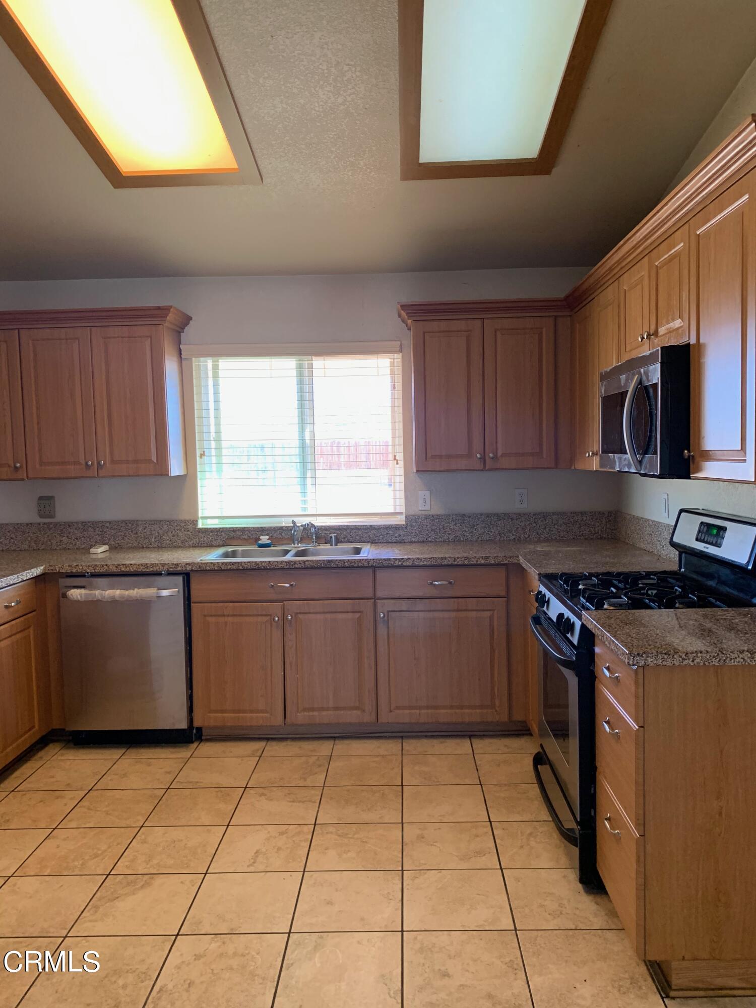 22159 Tehama Road Apple Valley, CA 92308 - Photo 9 of 26 a kitchen with stainless steel appliances granite countertop a stove a sink and a microwave