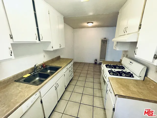 a kitchen with sink a stove and cabinets